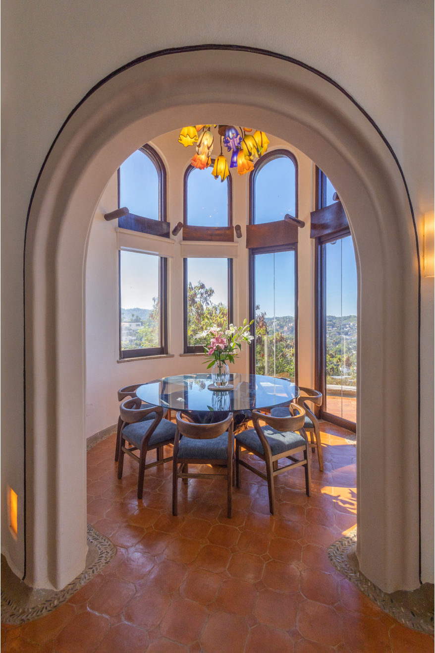 Inviting dining area featuring high ceilings, vibrant decor, and stunning views of the ocean.